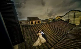 Một cặp đôi trèo lên mái ngói nhà cổ chụp ảnh cưới. Ảnh: FB 