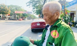Ông Năm “xích lô” ghi số điện thoại của mình lên chiếc mũ cối để khỏi quên