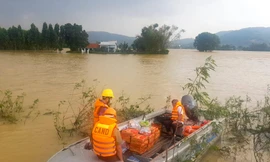 Công an huyện Tuy Phước dùng ca nô để hỗ trợ lương thực cho người dân bị nước lũ cô lập. Ảnh: Trương Định