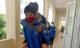 Xúc động hình ảnh tình nguyện viên cõng thí sinh đến tận phòng thi