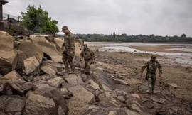 Binh lính đi bộ bên dòng sông Dnipro ở Novovorontsovka. (Ảnh: Guardian)