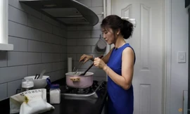 Chị Lee Young-min đang nấu canh rong biển cho gia đình. (Ảnh: Reuters)