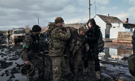 Lính Ukraine giúp đồng đội lên một chiếc xe cứu hộ ở chiến trường Bakhmut ngày 20/2. (Ảnh: AP)