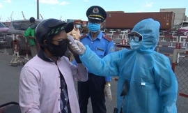 Nhân viên y tế đo thân nhiệt người dân tại các chốt kiểm soát phòng chống COVID-19.