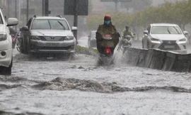 Người Sài Gòn bì bõm lội nước sau cơn mưa bất chợt đầu giờ chiều