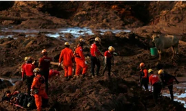 Các nhân viên cứu hộ đang tìm kiếm các nạn nhân trong biển bùn đất. Ảnh: Reuters