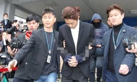 Ca sỹ Joon-young bị còng tay và chuyển từ nơi giam giữ ở đồn cảnh sát sang cơ quan công tố.