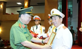 Bộ trưởng Tô Lâm trao Quyết định của Chủ tịch nước thăng cấp bậc hàm từ Thiếu tướng lên Trung tướng cho Thứ trưởng Trần Quốc Tỏ. (ảnh: mps)