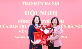 Phó Bí thư Thường trực Thành ủy Hà Nội Nguyễn Thị Tuyến trao Quyết định của Ban Thường vụ Thành ủy và tặng hoa chúc mừng đồng chí Nguyễn Thị Vân.