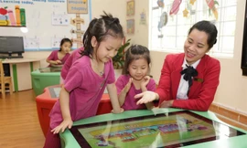 Giáo viên hướng dẫn trẻ học tập