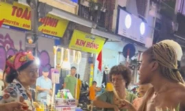 Hình ảnh người bán hàng rong bán 3 quả dứa với giá 500.000 đồng cho 2 du khách nước ngoài (ảnh cắt từ clip)