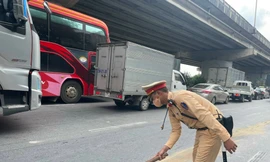 Cán bộ, chiến sỹ Đội CSGT đường bộ số 7 xử lý vết dầu loang tránh nguy hiểm cho người tham gia giao thông