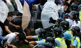 Một người biểu tình Hong Kong bị cảnh sát xịt thẳng hơi cay vào mặt. Ảnh: Business Insider