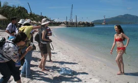 Phóng viên tác nghiệp ở Vinpearl, Nha Trang 2007 (người mẫu là Teresa Sam, sau trở thành Á hậu1 Hoa hậu Thế giới Người Việt). Ảnh: Dương Thị.