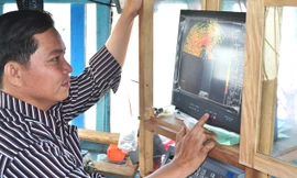Anh Trần Công Tăng bên máy dò ngang lắp đặt trên tàu cá