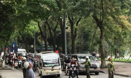 Nhân viên Cty TNHH MTV Công viên Cây xanh Hà Nội giăng dây chắn đường phục vụ cắt tỉa cây xanh.