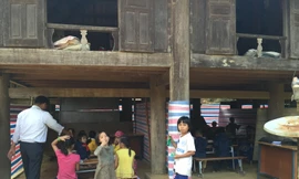 Học sinh túm tụm ngồi học nhờ dưới gầm nhà sàn của dân