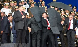 Lực lương an ninh Venezuela bảo vệ Tổng thống và các quan chức Chính phủ sơ tán khỏi hiện trường vụ nổ. (Nguồn: THX/TTXVN)