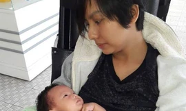 Hình ảnh Thúy Anh tiều tụy ngồi xe lăn ôm con mới sinh khiến nhiều người xót xa. 