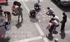 Người dân tranh nhau nhặt tiền trên trời rơi xuống.