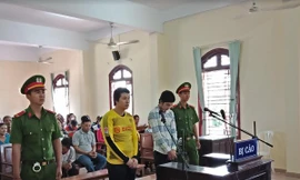 Bị cáo Hiếu (áo vàng), Bình (áo sơ mi sọc) chờ nghe tuyên án. Ảnh: Kim Hà.