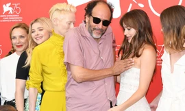 Đạo diễn Luca Guadgnino đặt tay lên ngực Dakota Johnson trong khi nữ diễn viên tỏ ra bối rối.