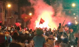 Cổ động viên đốt pháo sáng rực trên đường Trần Hưng Đạo, quận 1. (Ảnh: L. THOA)