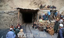 Công nhân chờ bên ngoài khu vực sập mỏ than ở Marwar ngày 5/5. Ảnh: THX/TTXVN