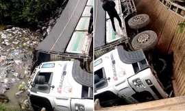 Xe tải và hàng hoá rơi xuống sông sau khi cầu sập. Ảnh: SGGP