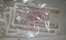 3 tờ tiền mệnh giá 1.000 đồng từ tiền hỗ trợ thiên tai được bà Lưu bọc túi bóng cất làm kỷ niệm.