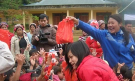 Thành viên CLB Tình nguyện trẻ chia quà cho em nhỏ xã Hua Bum