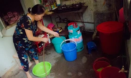 Bà Bạch Thị Quế đang bơm nước và xô đem về nhà để sinh hoạt. Ảnh: Thanh Hà.