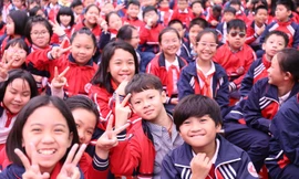 Các em học sinh trường Tiểu học Dịch Vọng A (Cầu Giấy, Hà Nội) hào hứng tại lễ phát động cuộc thi sưu tập và tìm hiểu tem Bưu chính "Cháu ngoan Bác Hồ mừng Đảng quang vinh". Ảnh: Bảo Anh