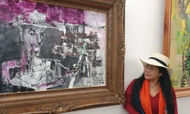 Văn Dương Thành bên bức chân dung Bùi Xuân Phái do chị vẽ.