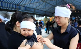 Người nhà thắt khăn tang cho con trai đồng chí Đỗ Mạnh Uy. Ảnh: Trường Phong