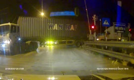 Hai xe container cố lách qua rào chắn khi tàu hỏa sắp tới