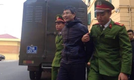 Giang Kim Đạt tươi cười khi bị dẫn giải tới tòa.