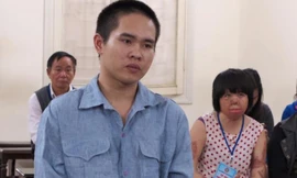 Nguyễn Văn Thành và người vợ xấu số của y phía sau.