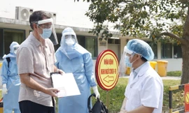 Giám đốc Bệnh viện Trung ương Huế Phạm Như Hiệp (bìa phải) chúc mừng bệnh nhân thứ 33 được chữa khỏi Covid-19 và dặn dò người này tiếp tục theo dõi sức khỏe theo quy định.