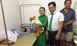 Tài xế Lê Phước Chính chụp hình lưu niệm cùng cháu bé sơ sinh, chị Ngọc cũng người nhà sản phụ này