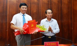 Ông Bùi Thanh Hà, Phó Bí thư Thường trực Tỉnh ủy TT-Huế (bìa phải) trao quyết định và tặng hoa, chúc mừng ông Phan Xuân Toàn. (Ảnh Anh Phong).