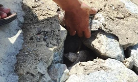 Đê ngăn lũ tại Quảng Vinh xây bằng đá hộc, chỉ cần dùng tay không có thể bóc gỡ từng mảng bê tông ra khỏi các phiến đá.