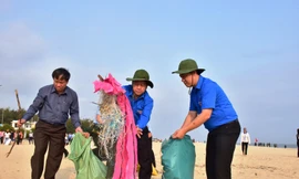 Chủ tịch Phan Ngọc Thọ (giữa) hăn hái gom nhặt rác, góp phần làm sạch môi trường bãi tắm Thuận An