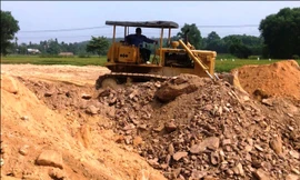 Đá tảng, rễ cây tuồn vào công trường dự án TĐC bất thành sau khi bị báo chí phát hiện, nên buộc phải đẩy ra bên rìa khu đất san nền.