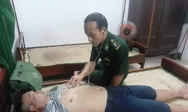 Kiểm tra sức khỏe ngư dân bị đắm thuyền sau khi được bộ đội biên phòng và dân địa phương đưa vào bờ an toàn