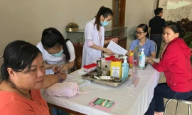 Nhân viên y tế lấy mẫu máu tầm soát ung thư cho người lao động.