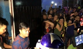 Phúc XO tươi cười khi ra khỏi nhà để về trụ sở công an.