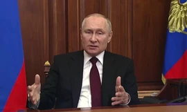 Binh lính Ukraine đứng cạnh một chiếc xe tăng bị hỏng gần Kharkov mà họ nói là của quân đội Nga ngày 24/2. (Ảnh: Reuters)