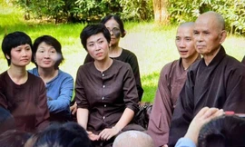 Ca sĩ Lô Thủy (thứ ba từ trái sang) ngồi cùng Thiền sư Thích Nhất Hạnh trong một khóa tu tại Làng Mai Thái Lan. Ảnh: NVCC