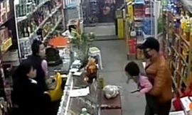 Hình ảnh từ camera giám sát cho thấy người đàn ông bịt mặt tay cầm dao giữ bé gái 3 tuổi làm con tin trong cửa hàng ở Thiên Tân, Trung Quốc
